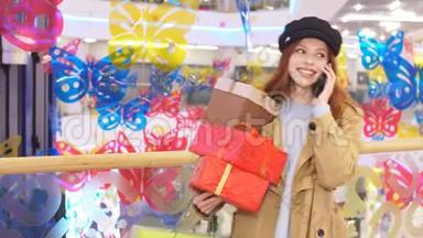 购物中心内部快乐购物狂女孩的肖像，用手机进行情感交流